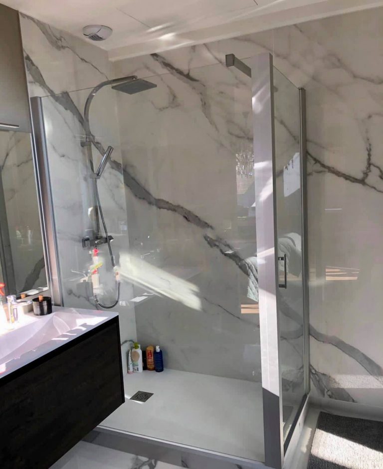 Salle de bains avec un mur en marbre et une cabine de douche